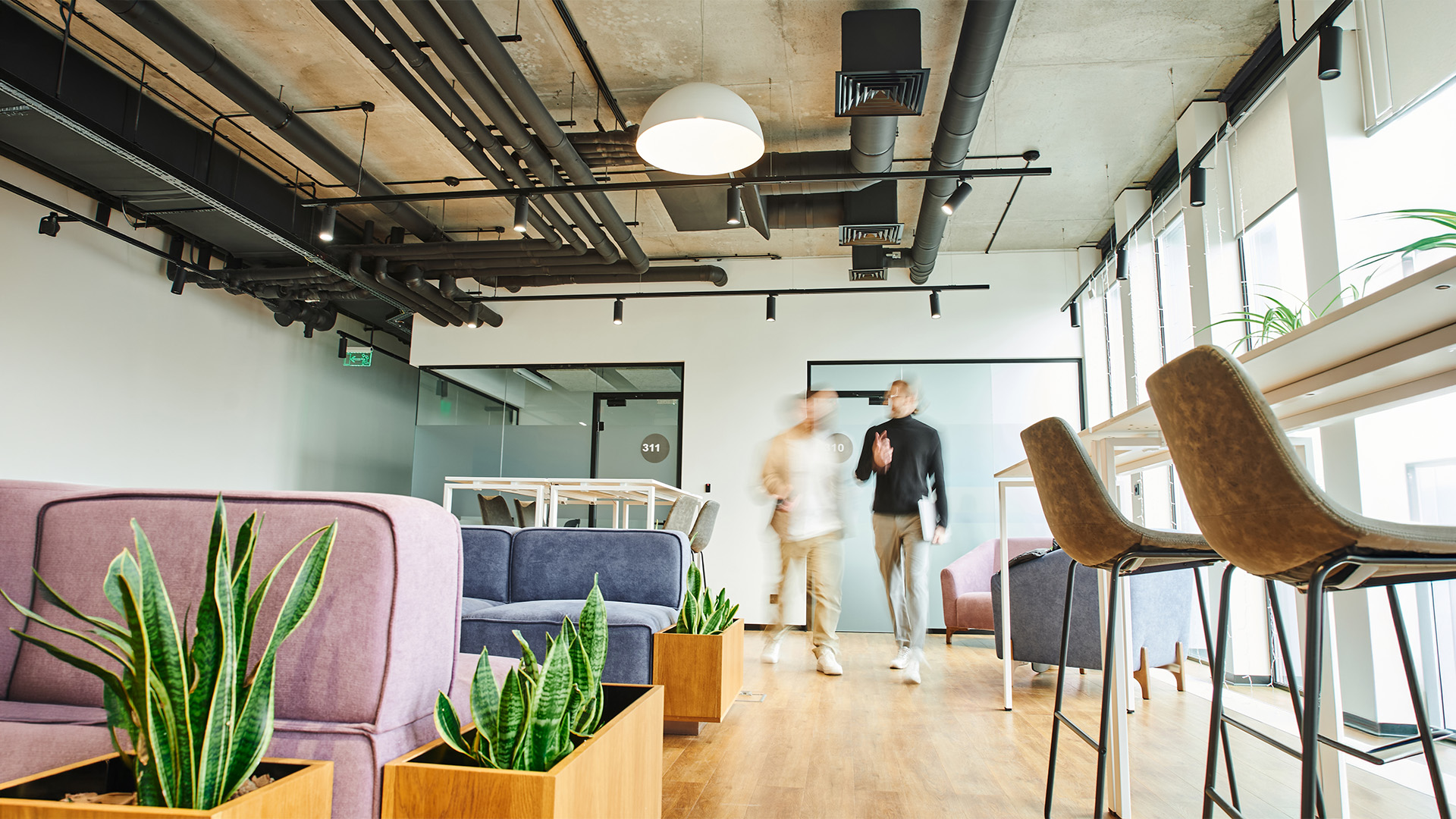 two people walking through an office