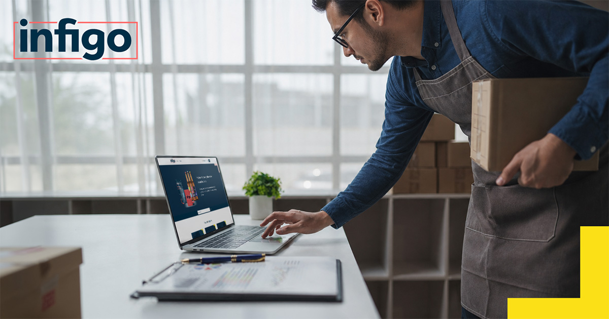 Man reviewing a web-to-print storefront on a laptop in a warehouse