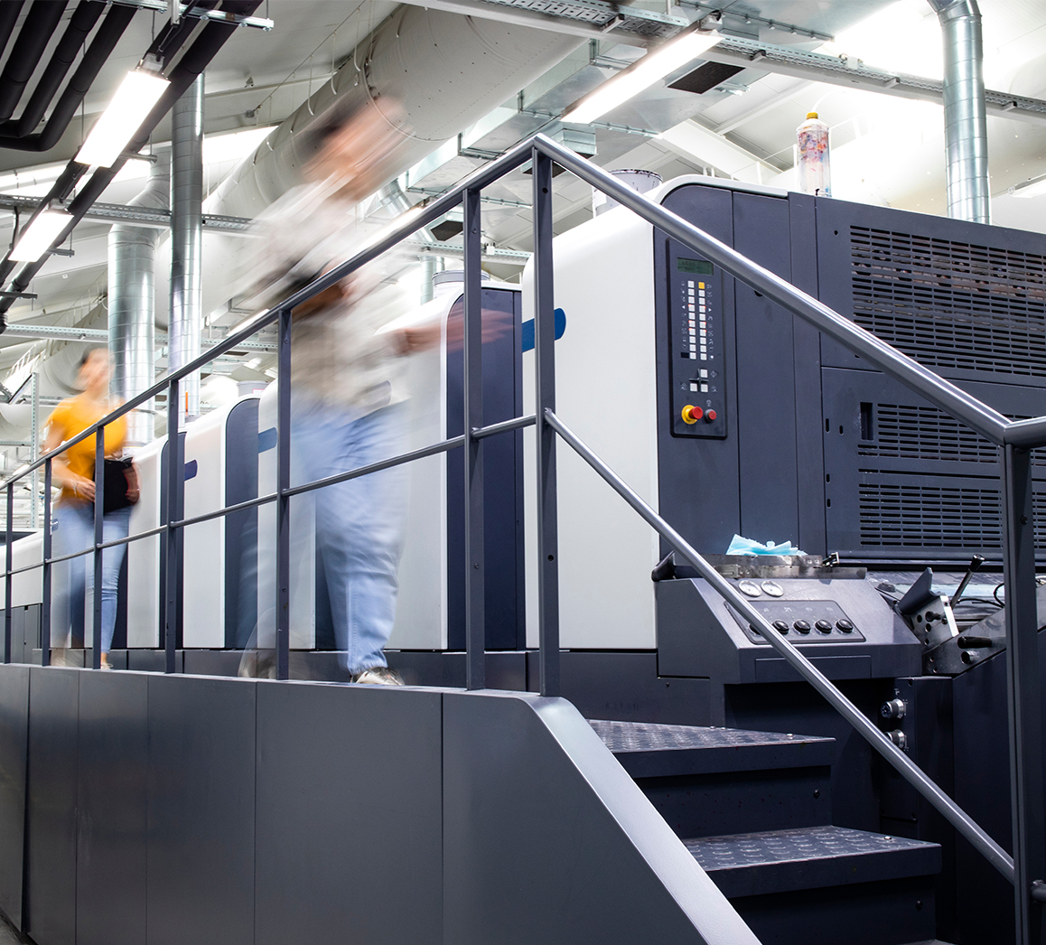 People on walkway attached to industrial printer