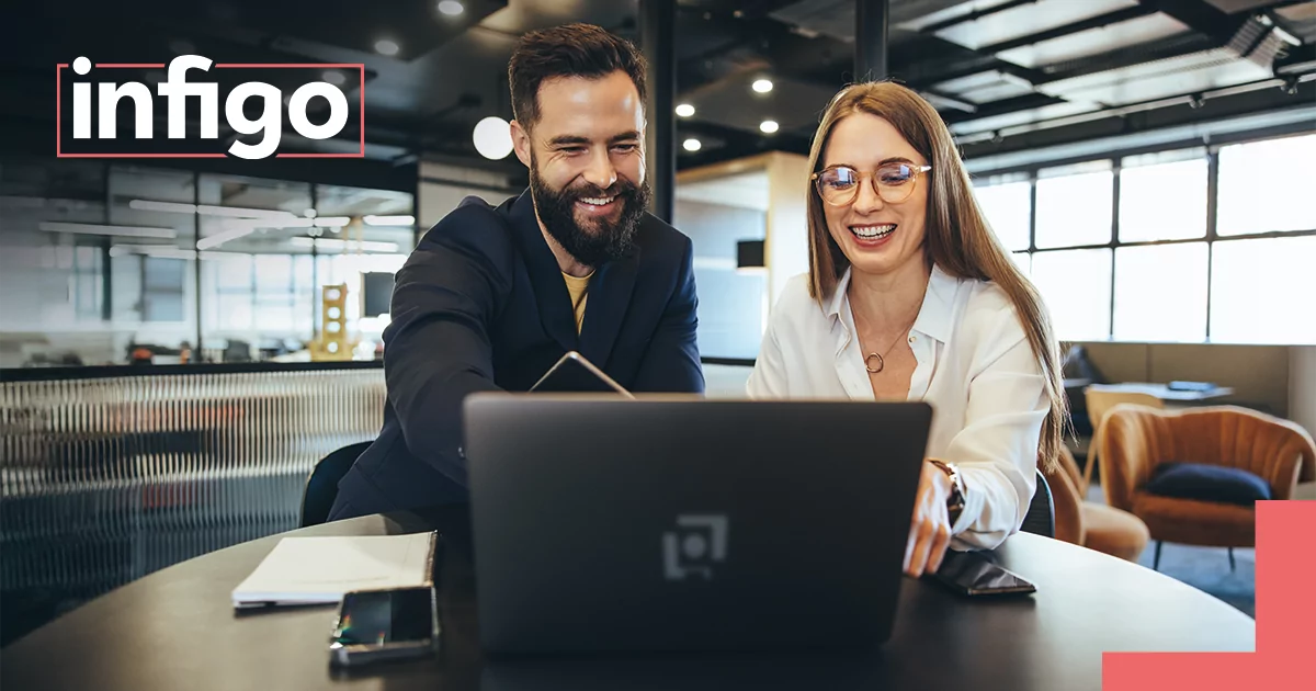 Two colleagues in an office working on a laptop
