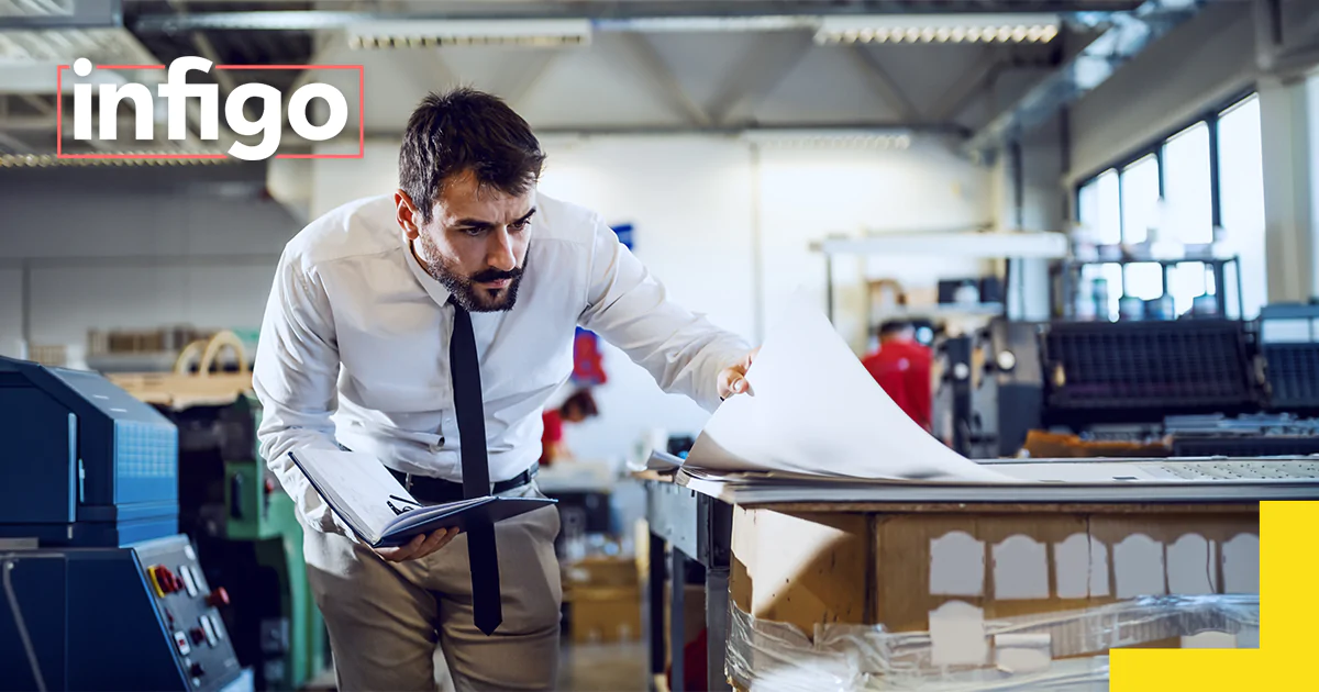 Print shop technician manually checking a job's quality before it reaches production